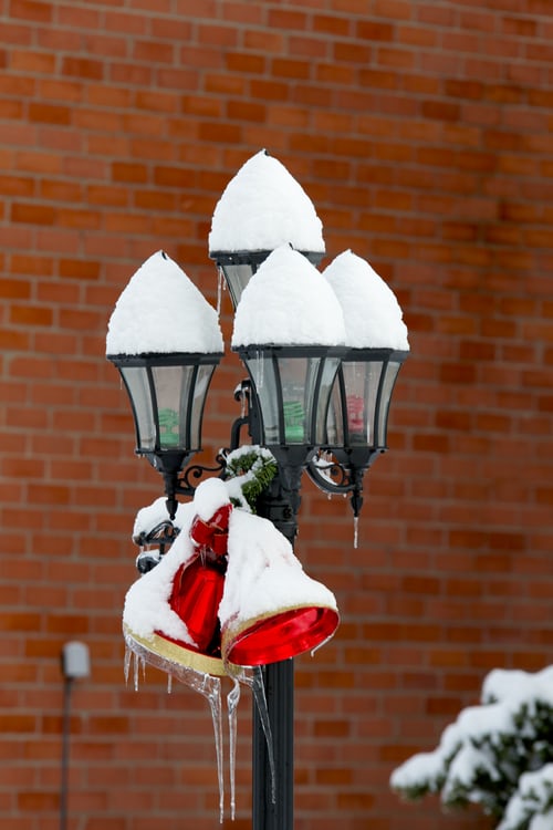 LED lights in a street lamp with red bells hanging. Set up by Christmas Light Installation Professionals